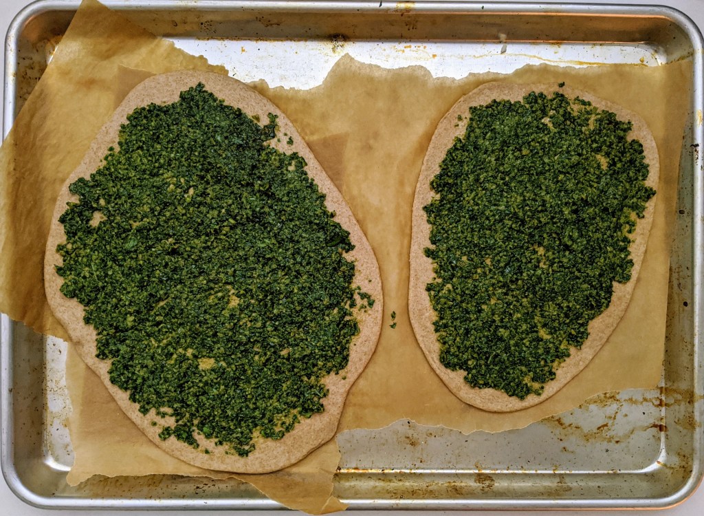 two zesty pizzas ready for baking Baking tray with two zesty pizzas primed for the oven