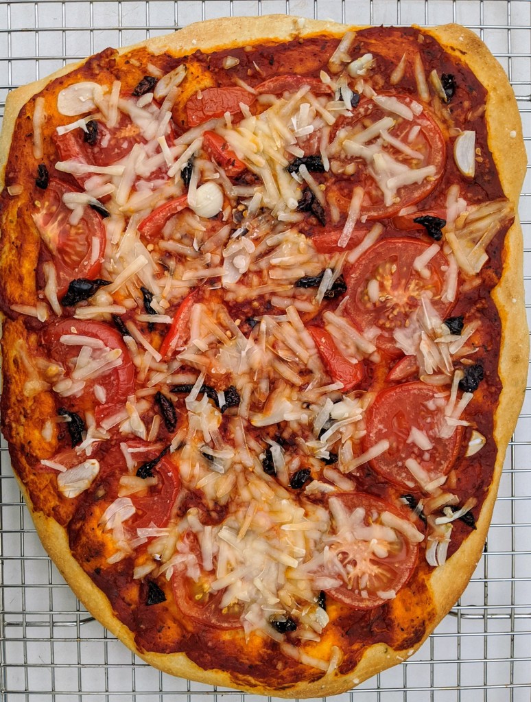 Baked Il Diavolo pizza with garlic, tomatoes, vegan mozzarella, and spices
